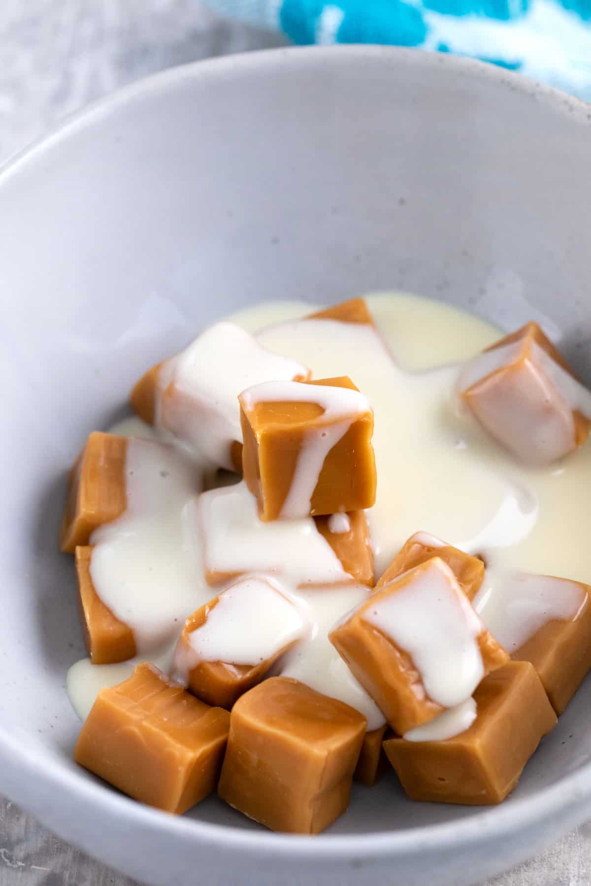 carmel candies and evaporated milk in a bowl for melting.