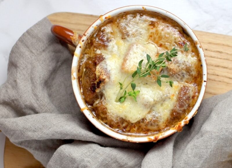 french onion soup with melted cheese on a cutting board