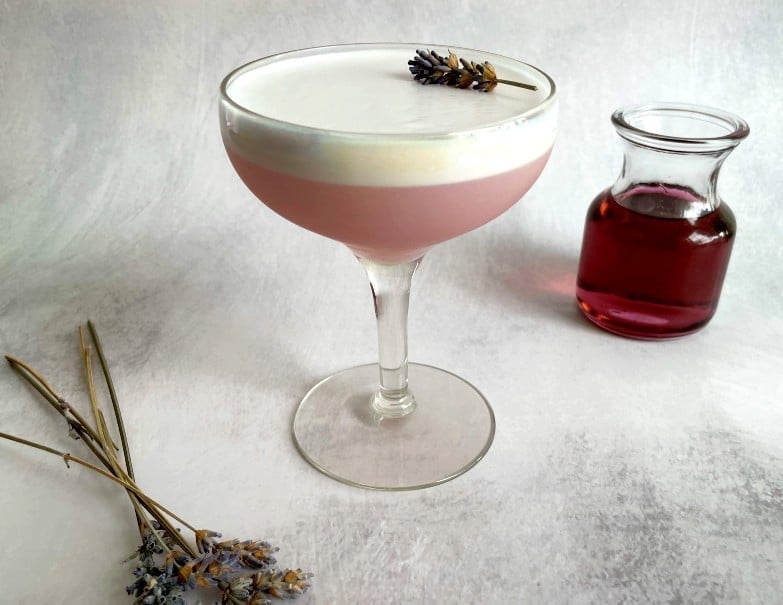 lavender pisco sour with syrup and lavender sprigs