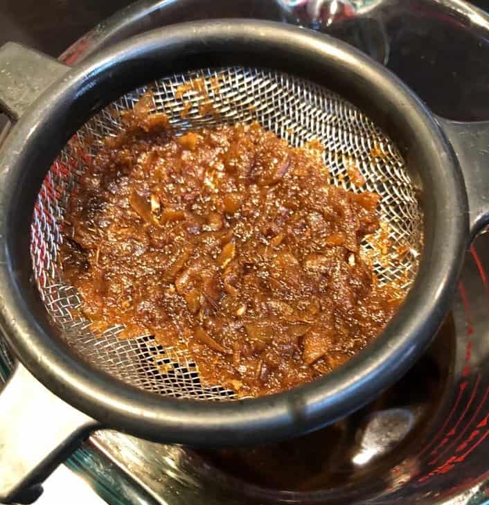 straining solids from homemade gingerbread syrup.