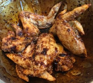 baked chicken wings in a bowl with sauce