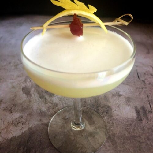 gin elderflower cocktail with cherry and lemon peel