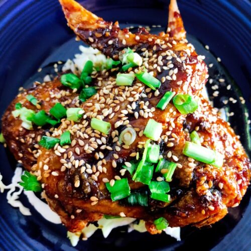 Crispy Baked Asian Chicken Wings on a plate with chopped green onions and baked sesame seeds for garnish