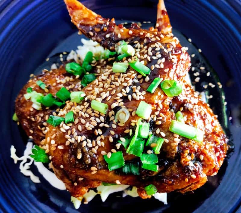 Crispy Baked Asian Chicken Wings on a plate with chopped green onions and baked sesame seeds for garnish