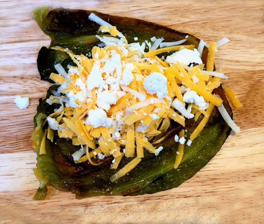 roasted poblano pepper cut open and stuffed with cheese.