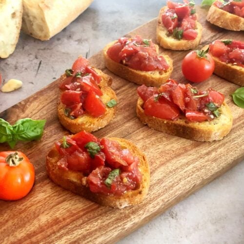 bruschetta on toasted bread on a cutting board