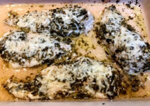 chicken with pesto and cheese in a baking dish