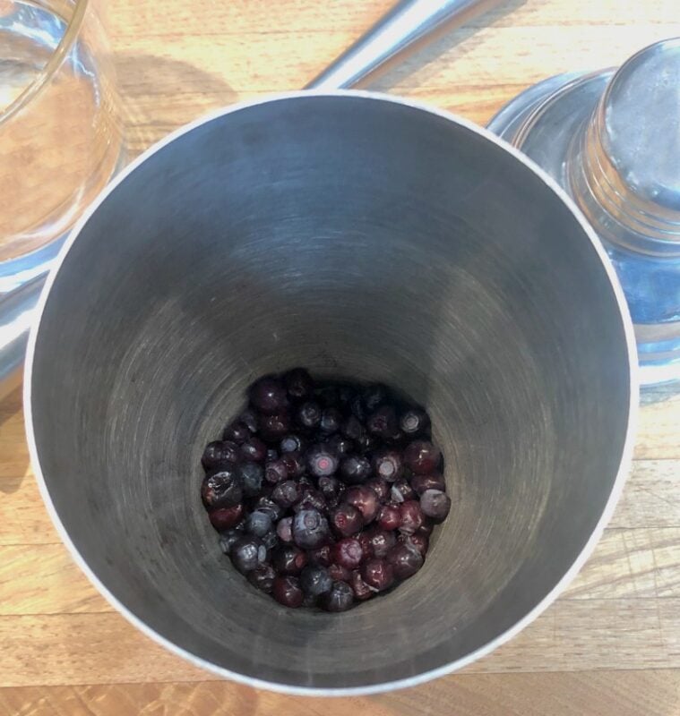 huckleberries in a cocktail shaker before muddling
