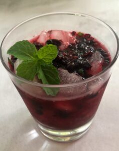 huckleberry cocktail with mint garnish