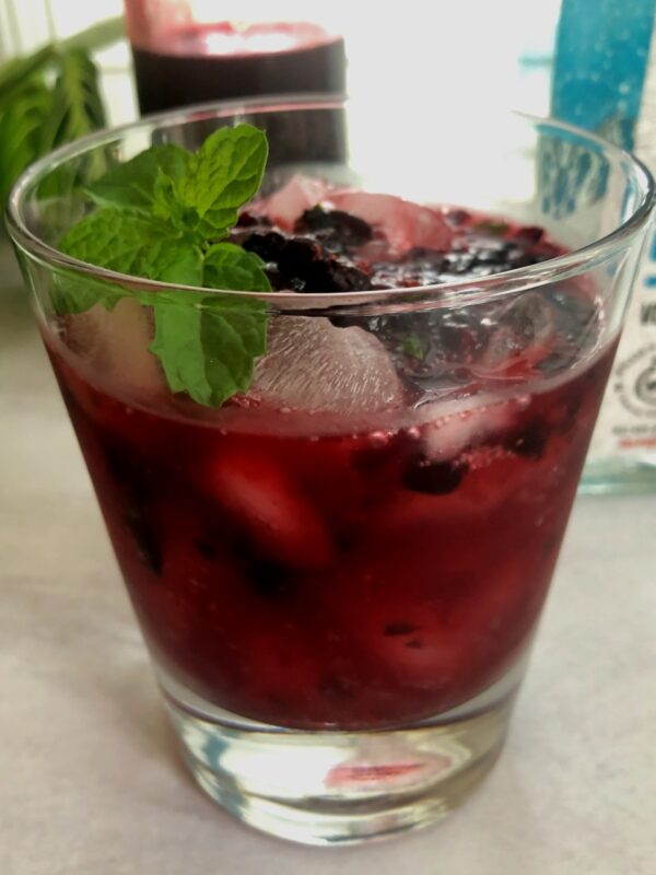 huckleberry cocktail with fresh huckleberries and fresh mint