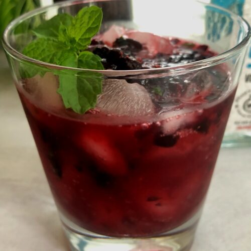 huckleberry cocktail with mint sprig