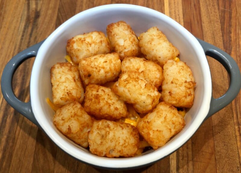 tater tots in oven-safe dish with second layer of tots