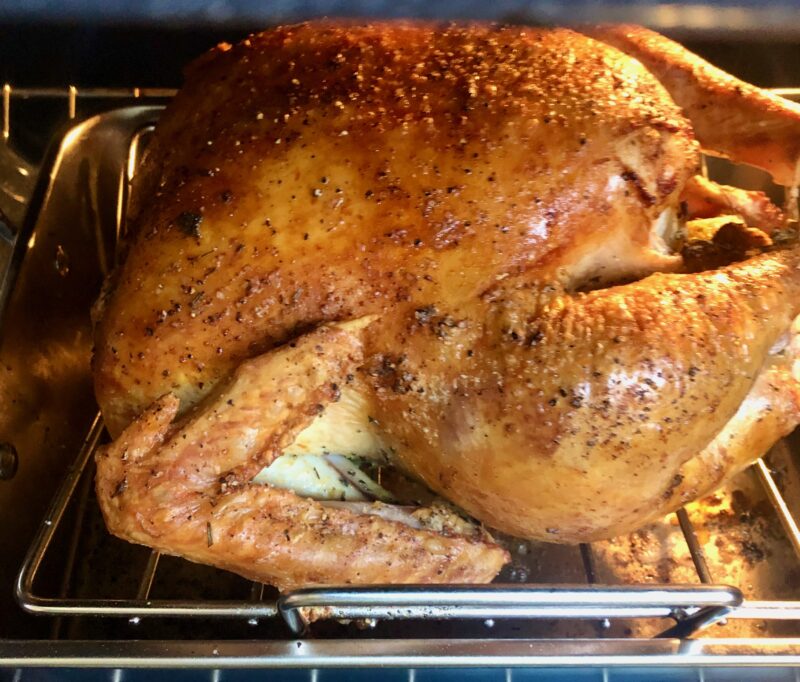 roasted turkey on a roasting pan in the oven
