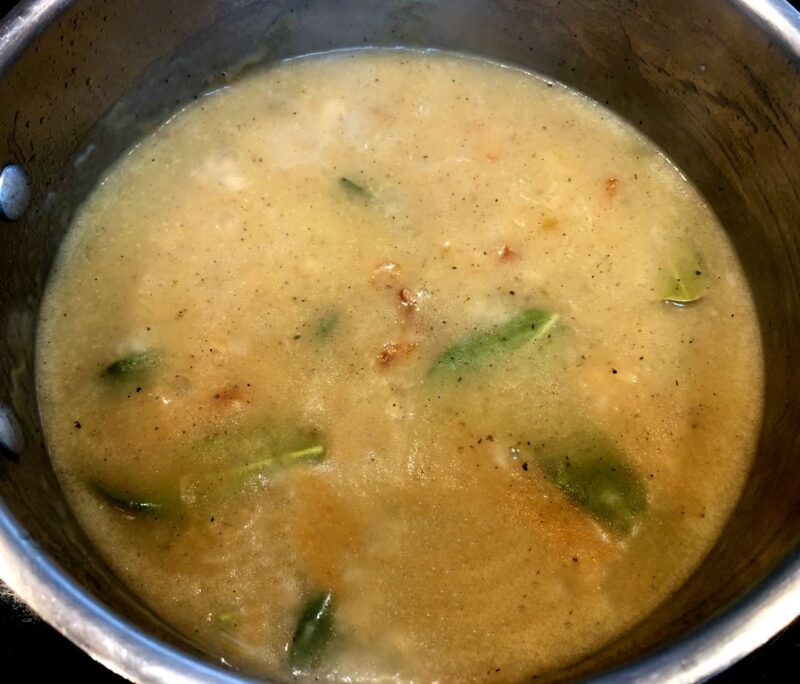 gravy base with herbs in a saucepan
