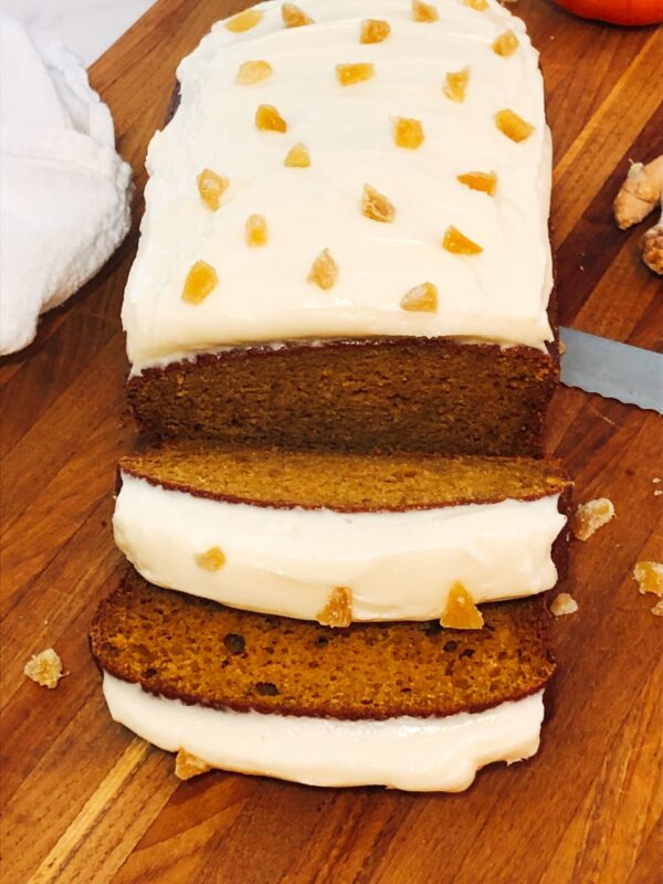 sliced pumpkin bread with icing on a cutting board