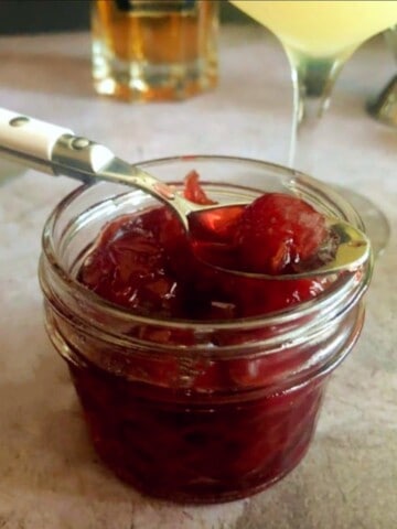 amarena cocktail cherries in a jar with a spoon.