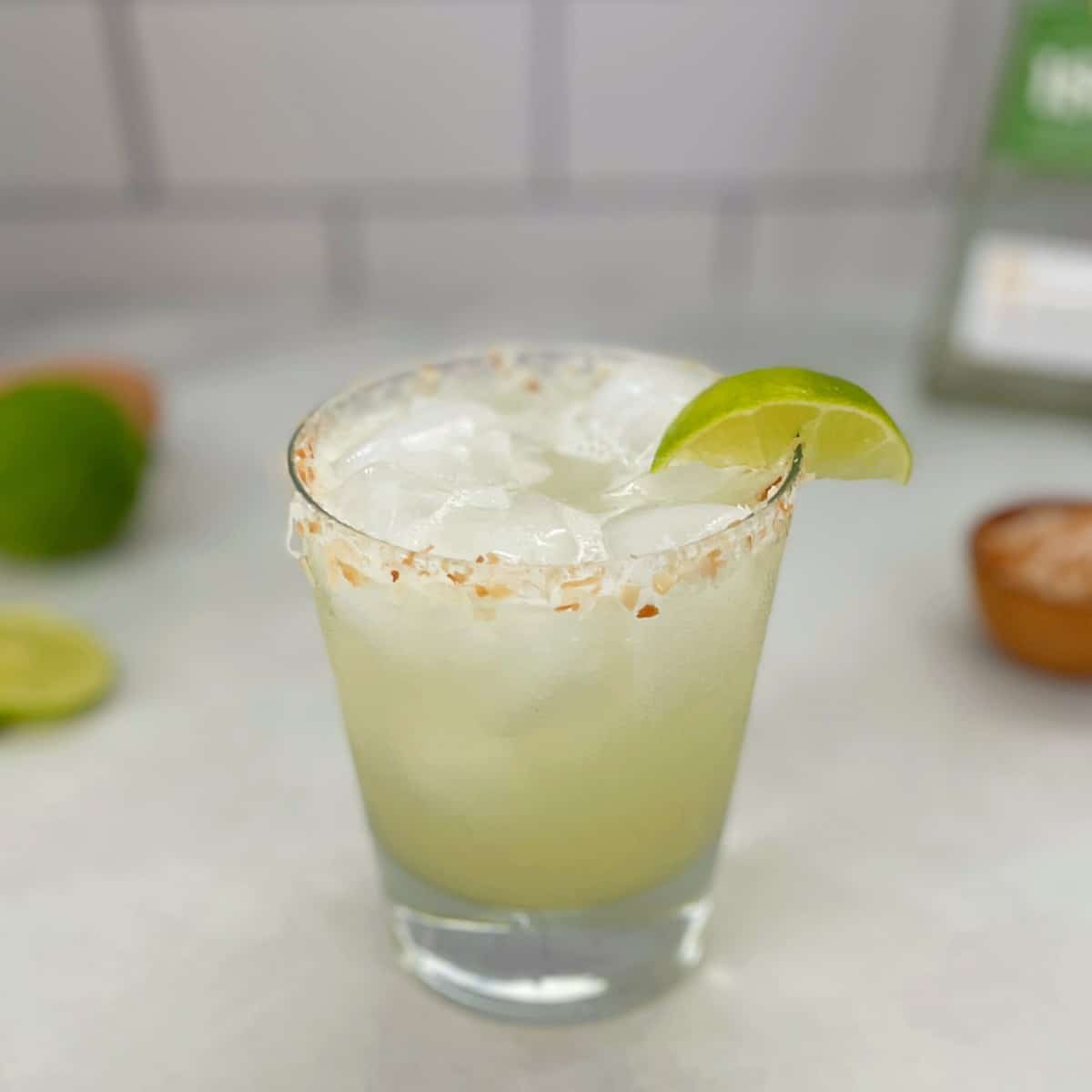 coconut lime margarita with a lime wedge.