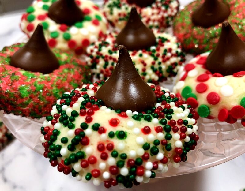 almond kiss cookies with holiday sprinkles on a plate