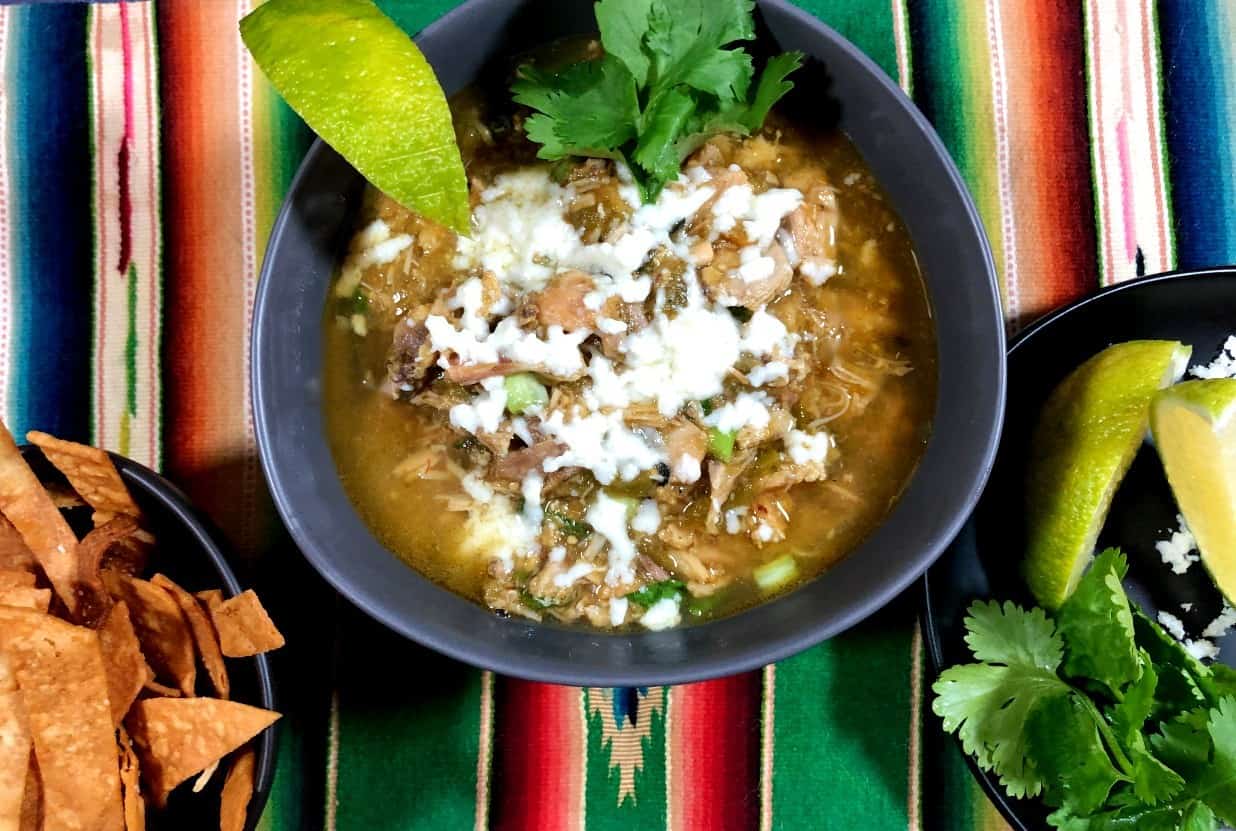 bowl of green chicken chile with sides.