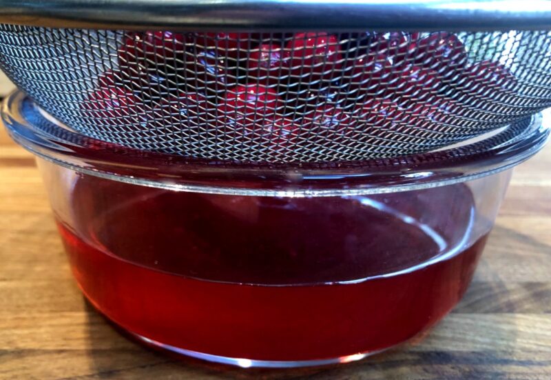cranberries being strained from syrup