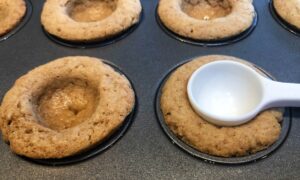 graham cracker cups with a spoon making a hole