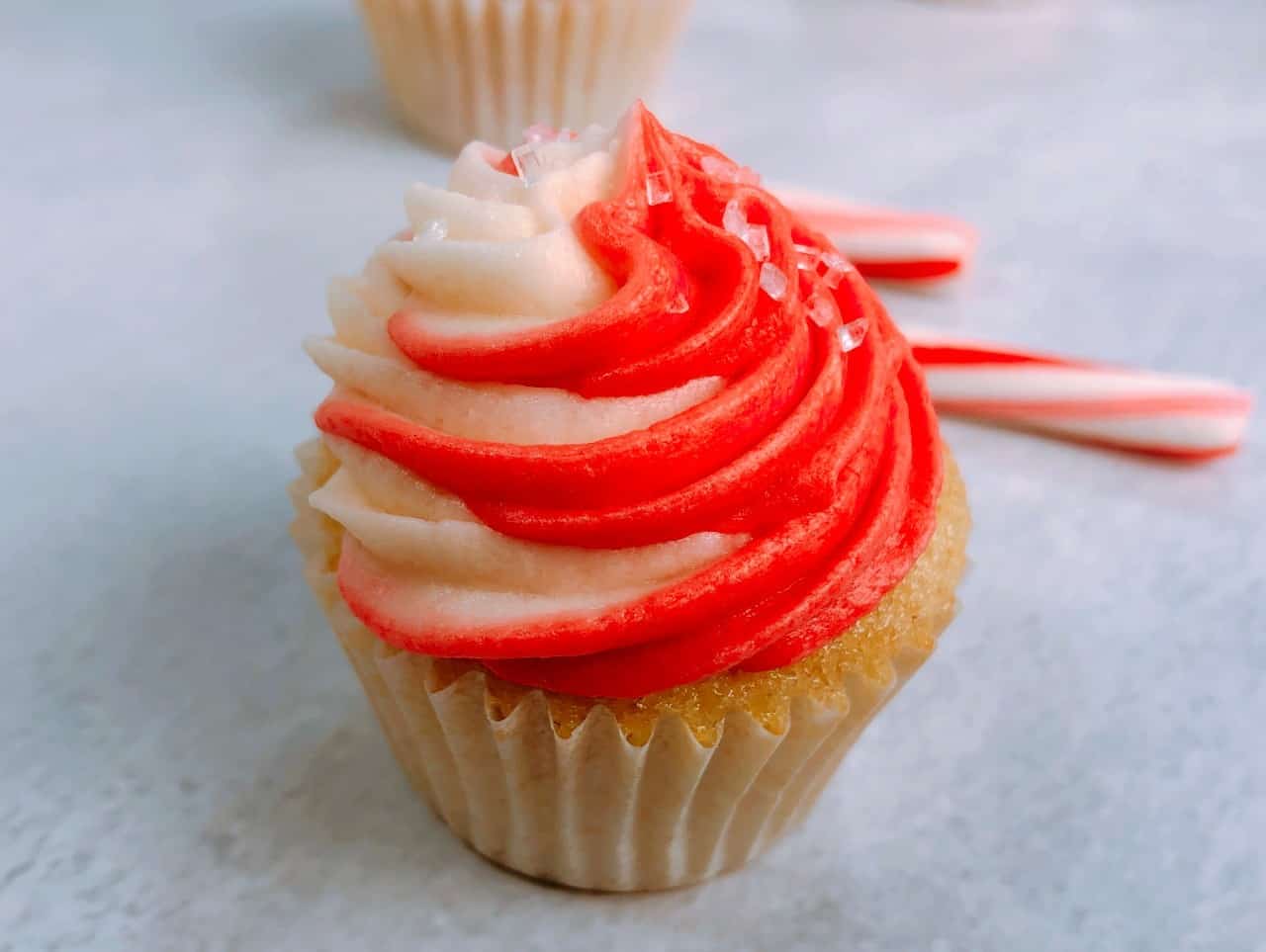 mini candy cane cupcake with swirled peppermint frosting.