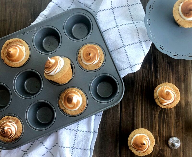 s'mores cups with toasted meringue on a table and in a pan