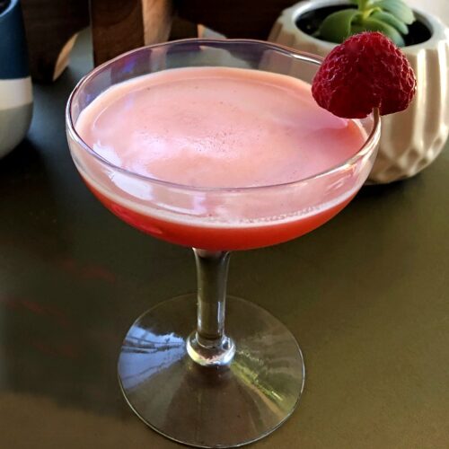 strawberry gin cocktail in a coupe glass with a strawberry garnish