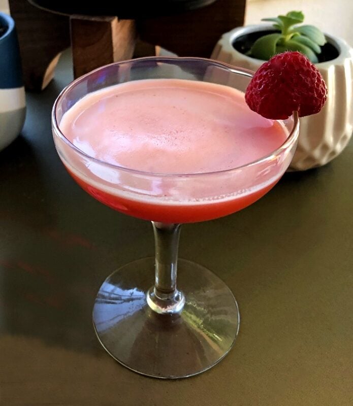 strawberry gin cocktail in a coupe glass with a strawberry garnish.