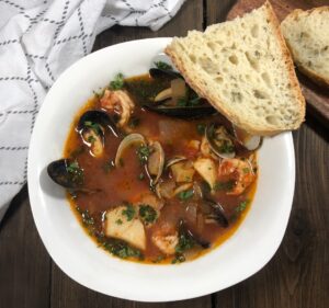 a bowl of cioppino with fresh bread