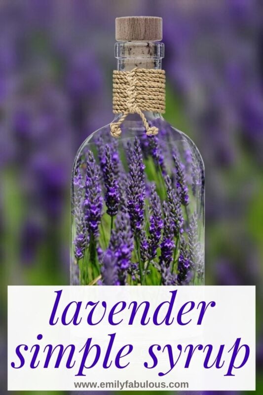 a glass bottle with lavender inside in front of a field of lavender