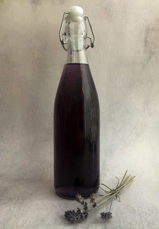 lavender syrup in a bottle with a sprig of dried lavender