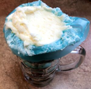 piping bag in a glass filled with frosting
