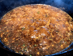 sauce for sticky beef and broccoli in a cast-iron pan
