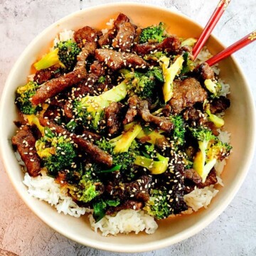 sticky beef, broccoli and rice in a bowl with chopsticks