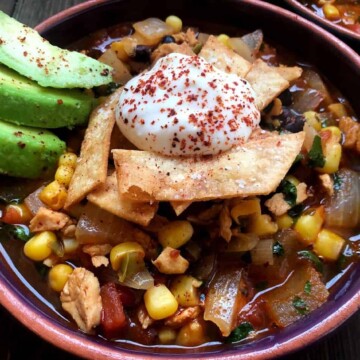 bowl of tortilla soup with avocado and sour cream