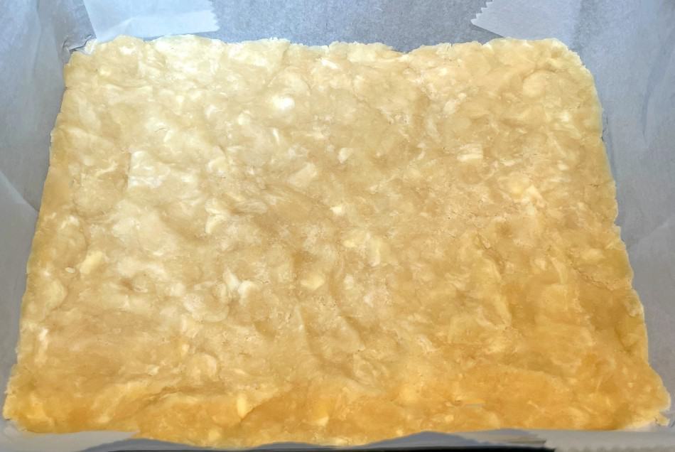crust for bars in a pan with parchment paper