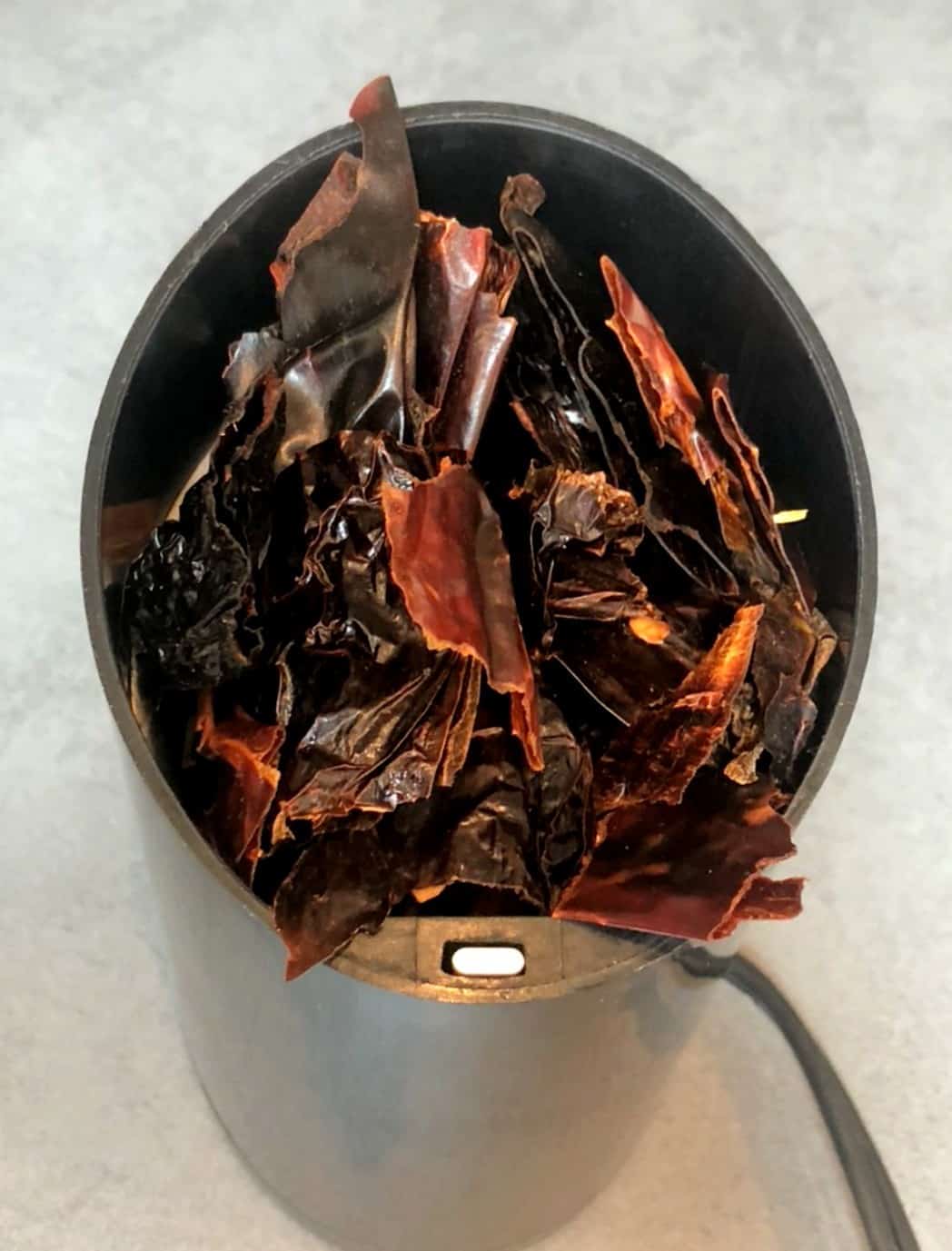 dried, cut up Mexican chiles in a grinder