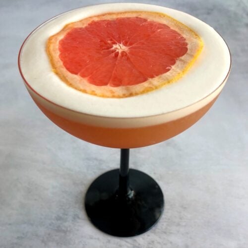 grapefruit pisco sour with grapefruit slice on top