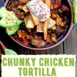 a bowl of chunky chicken tortilla soup with sour cream