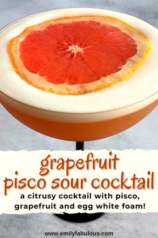 a grapefruit pisco sour in a coupe glass with a slice of grapefruit on top of the foam