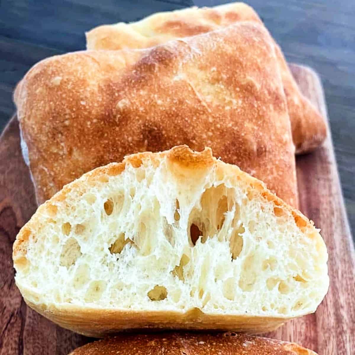 ciabatta rolls on a plate and sliced in half.