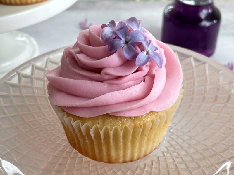 a lilac cupcake on a pink platter