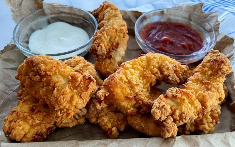 air fried chicken tenders on a tray with condiments