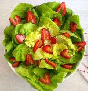 butter lettuce and strawberries in a bowl