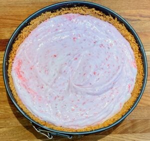 strawberry ice cream cheesecake pie before freezing