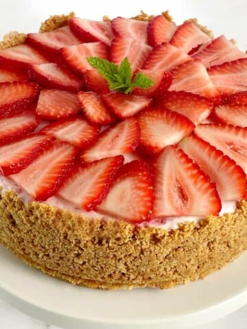 strawberry ice cream cheesecake pie with sliced fresh strawberries on top