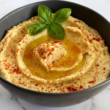 a bowl of homemade hummus with paprika on top