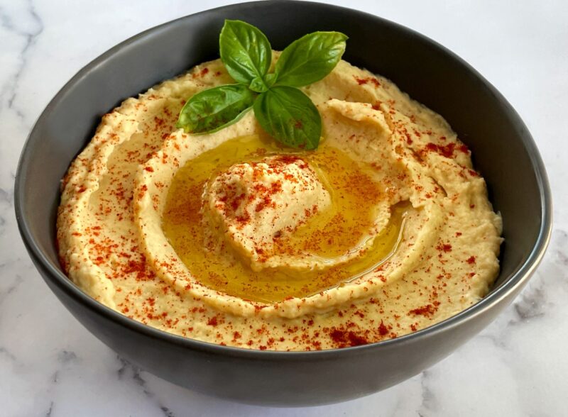 a bowl of homemade hummus with paprika on top