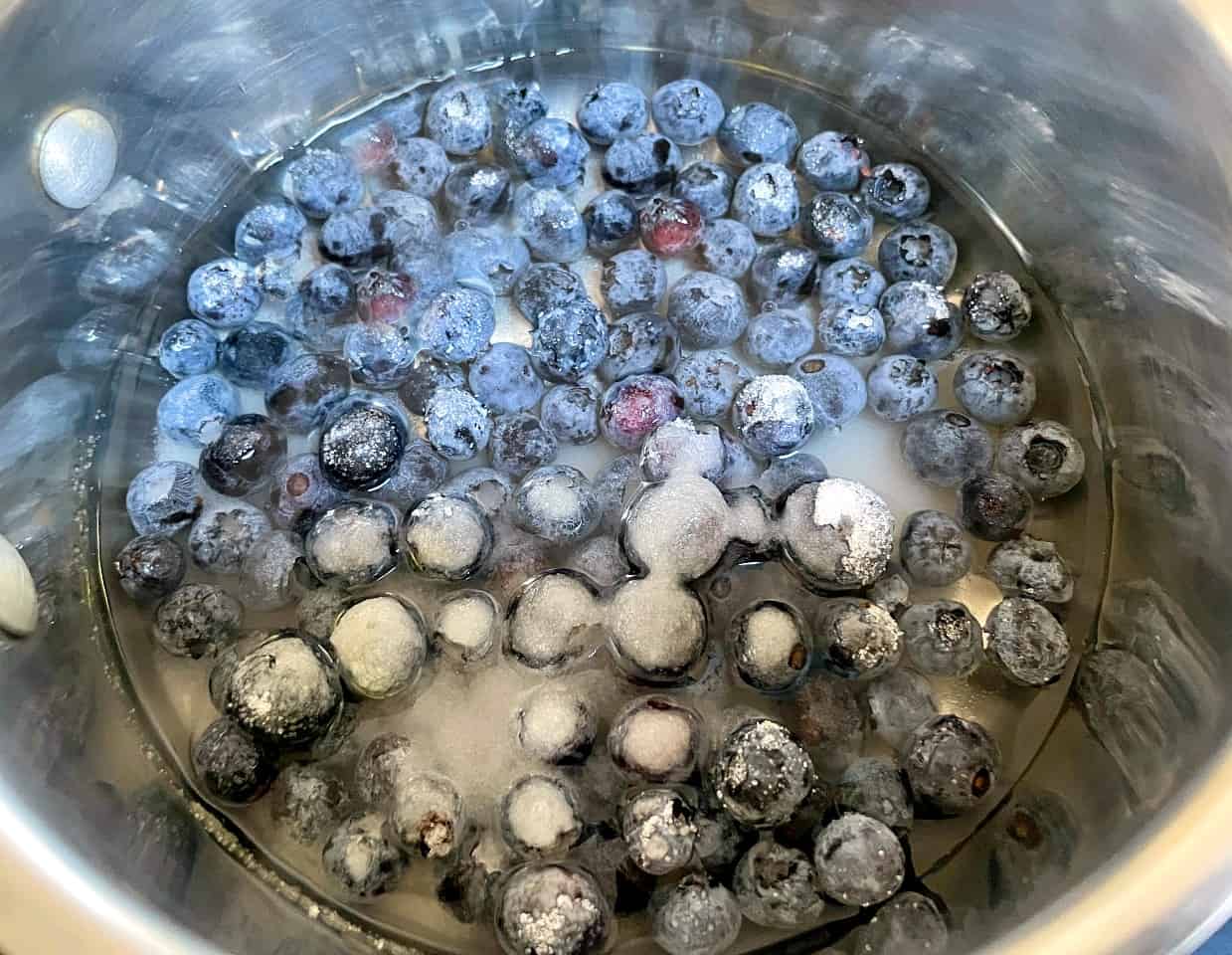 blueberries and sugar in a saucepan